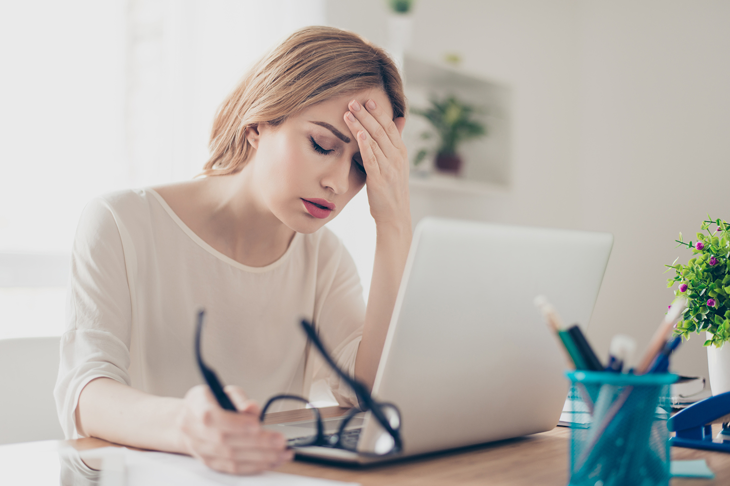 Overworked businesswoman suffering from headache and thinking ho